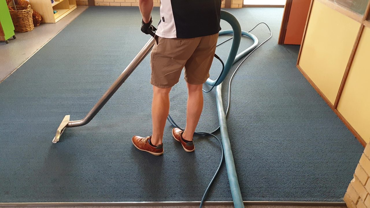 Hot water extraction on childcare carpet in Perth, the wand flushing out the soil and organic matter that a sanitiser alone can never remove.