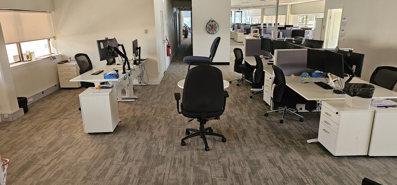 An open-plan Perth office on grey carpet tiles, where the carpet is checked alongside the air conditioning before a clean is booked for complaints.