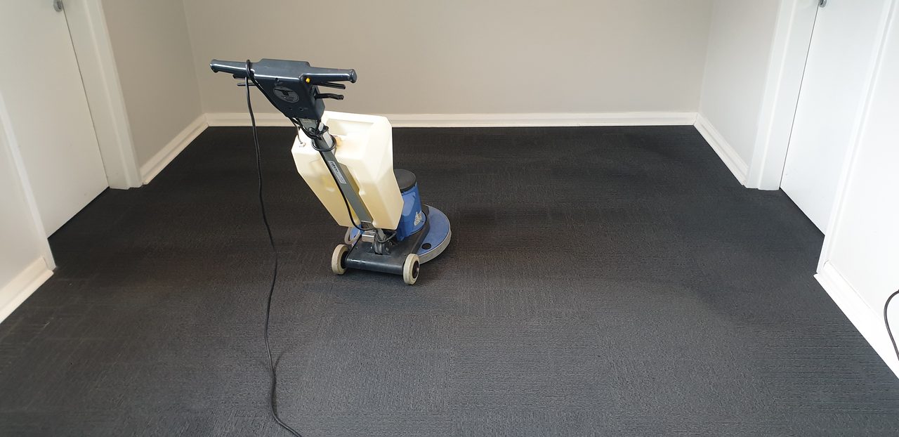 Charcoal ribbed carpet tiles deep cleaned in an empty Perth office, the soil scrubbed out of the pile while the room is clear