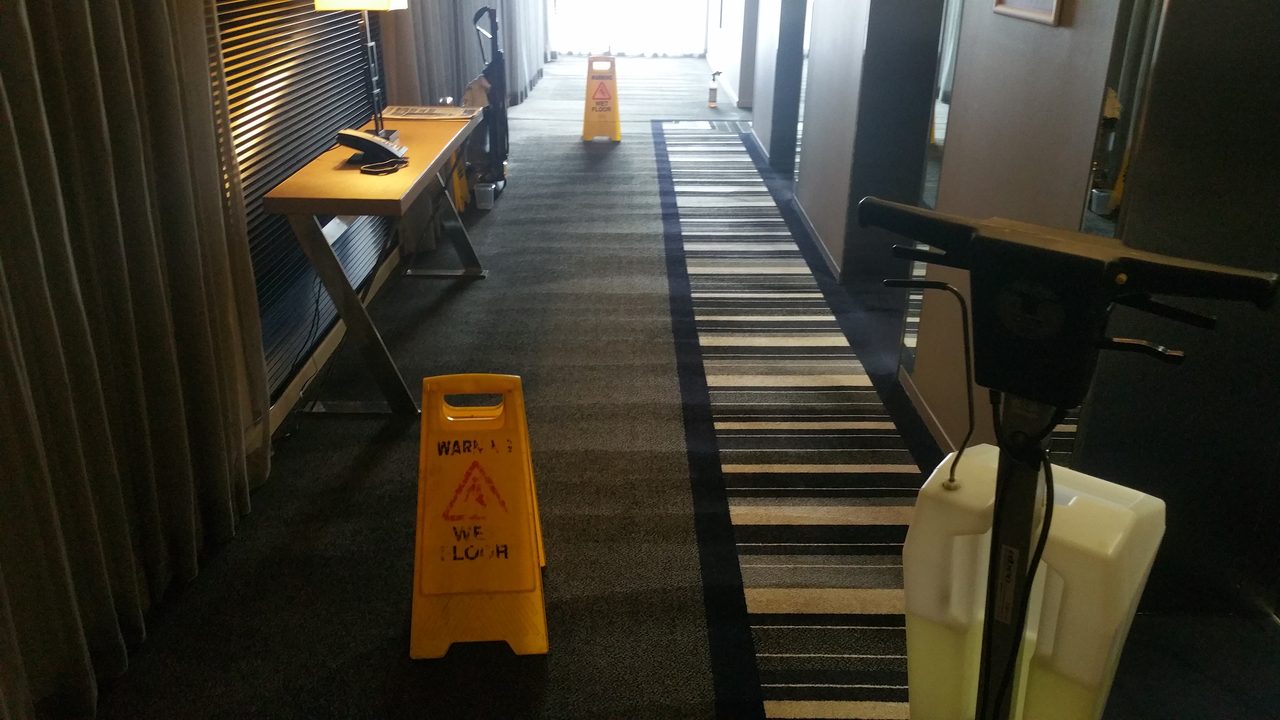 Wet floor signs set out along a Perth hotel corridor while the carpet is cleaned, keeping guests safe as it dries