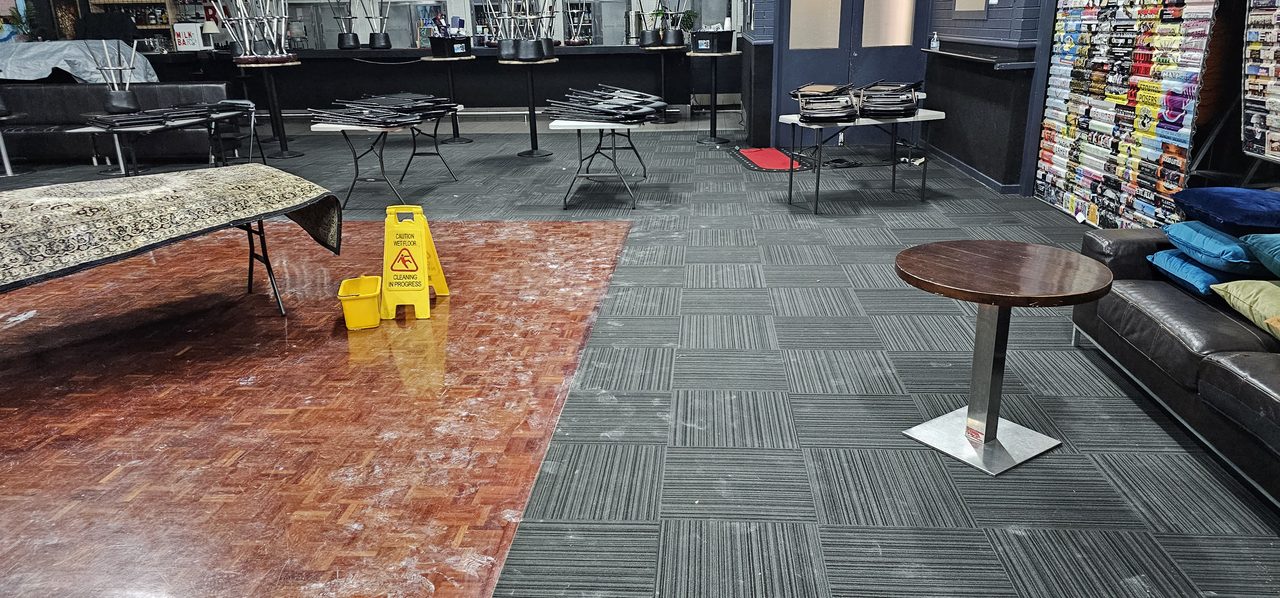 Grey carpet tiles cleaned up to the dance floor of a Perth venue, with wet floor signs out while the room dries