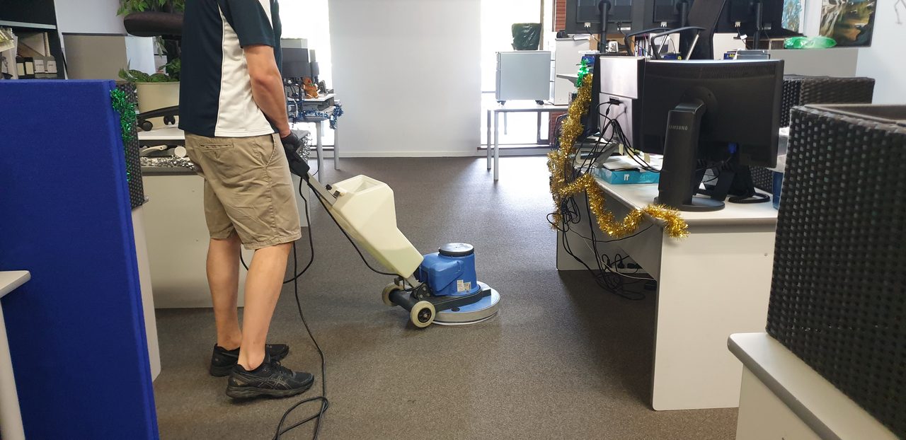 An encapsulation clean in a Perth open plan office, the scrubbing machine working the solution into the pile between desks