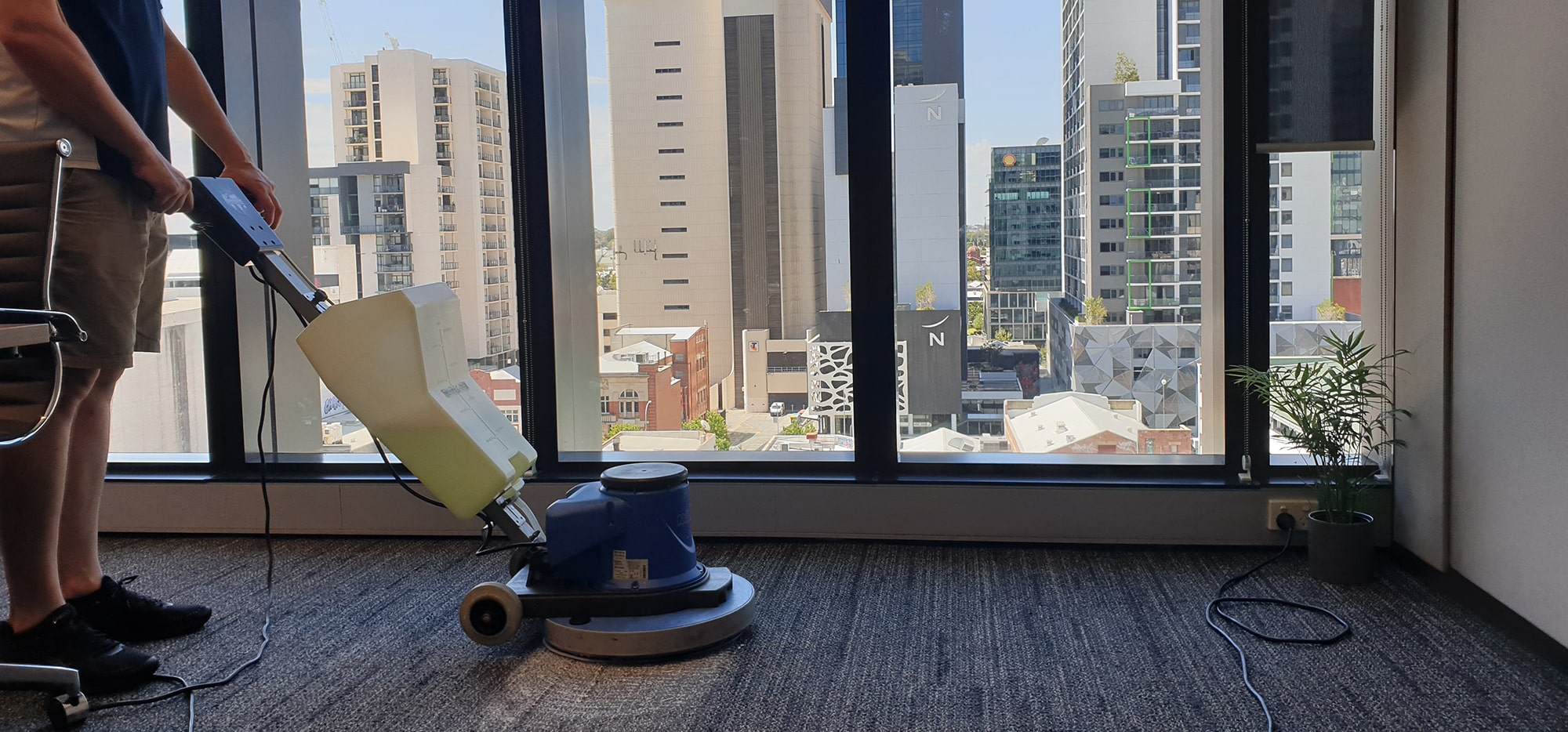 Our scrubbing machine on the carpet of a Perth city high-rise office, cleaning right up to the window line