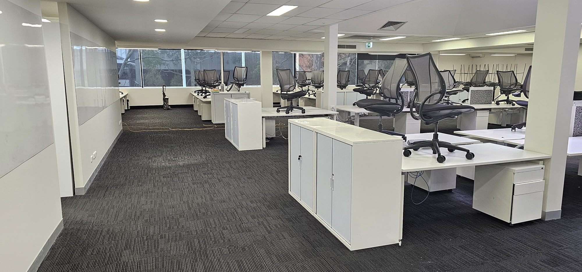 An open plan Perth office with its charcoal carpet tiles freshly cleaned between the desks and storage units