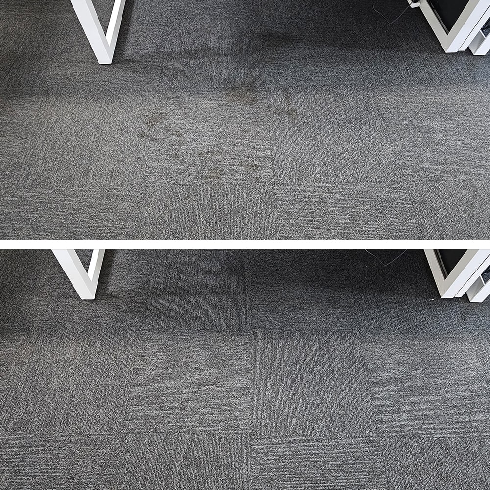 Spill patches beneath a desk in a Perth office, removed from dark grey carpet tiles so the floor looks uniform again