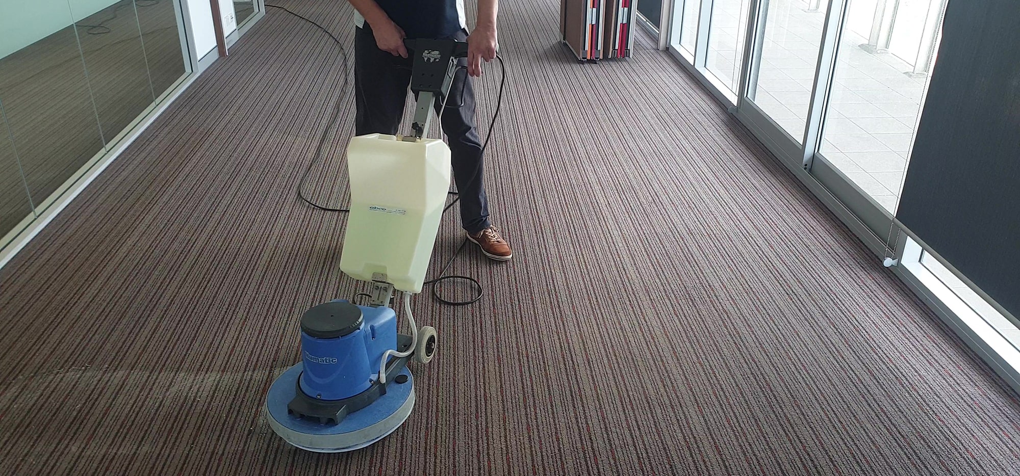 Our scrubbing machine working cleaning solution through the striped carpet of a Perth office corridor