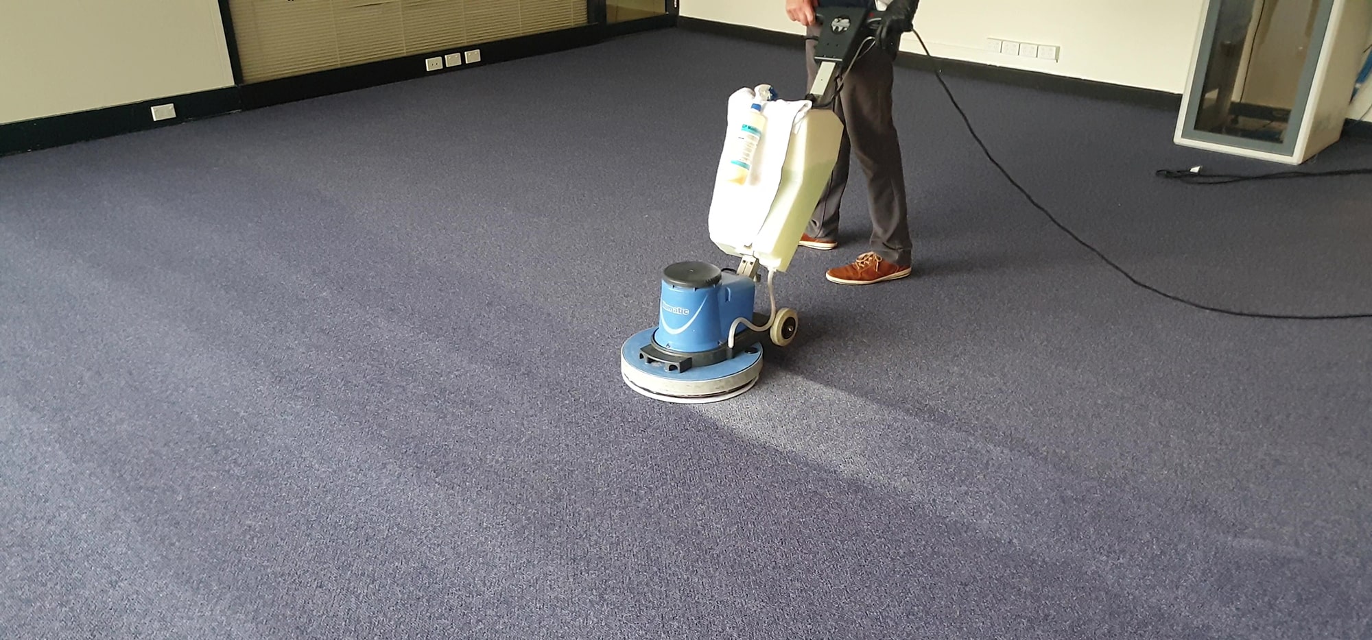 Navy commercial carpet in Perth scrubbed with our machine, each pass lifting soil from the pile