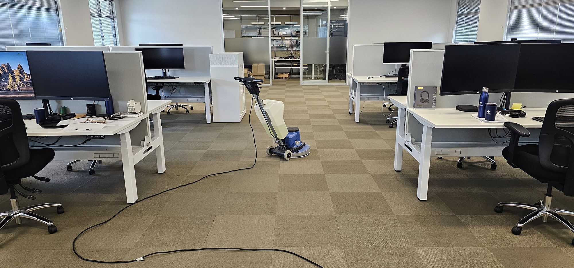 Checkerboard carpet tiles cleaned through a Perth open plan office, between desks set up for the working day