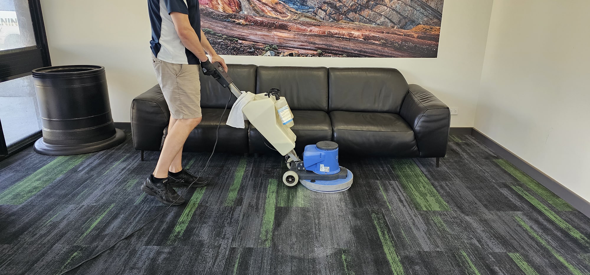 Grey and green carpet tiles scrubbed in front of a Perth office lounge, cleaned right up to the sofa