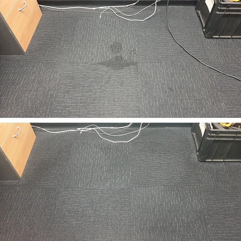 A dark spill under a Perth workstation, cleaned from charcoal carpet tiles until the tile looks like its neighbours