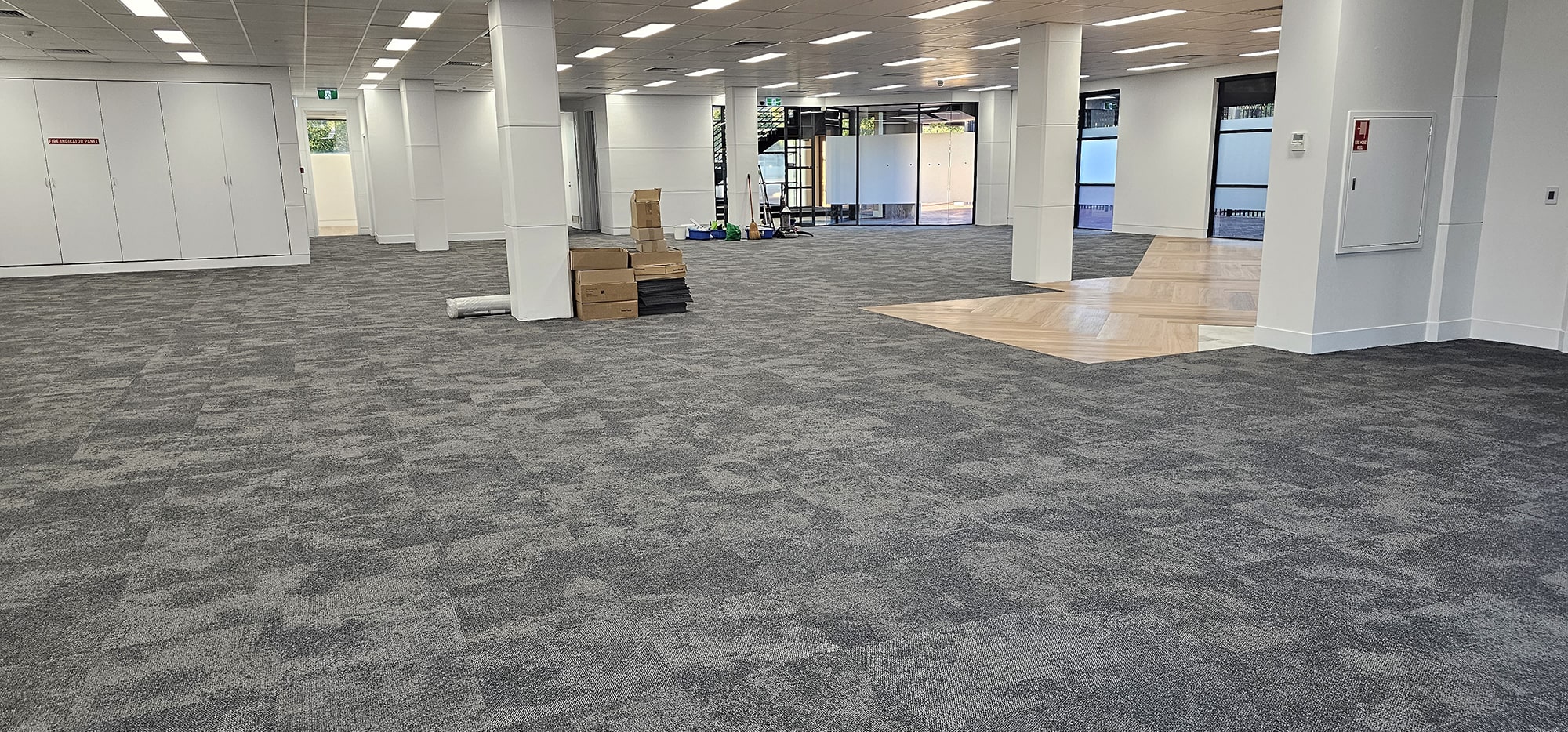 A whole open Perth office floor of grey carpet tiles, cleaned while the space stands empty