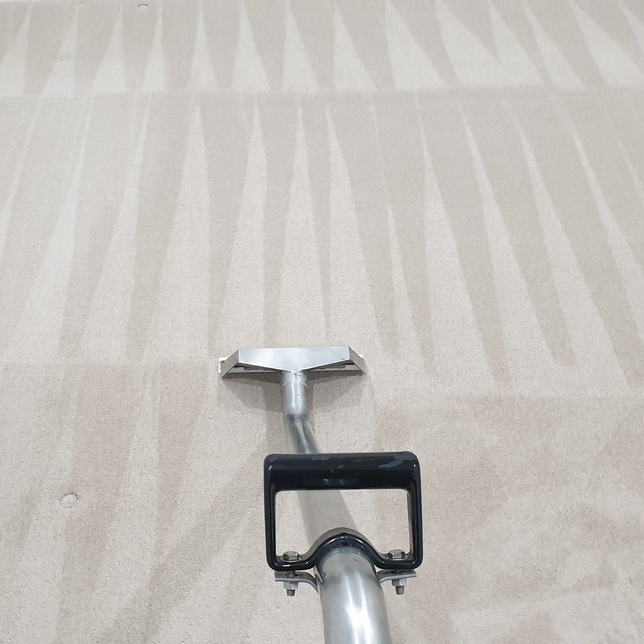 Carpet steam cleaning in Perth, our hot water extraction wand on cream carpet, each rinse stroke set straight and overlapping the one beside it.