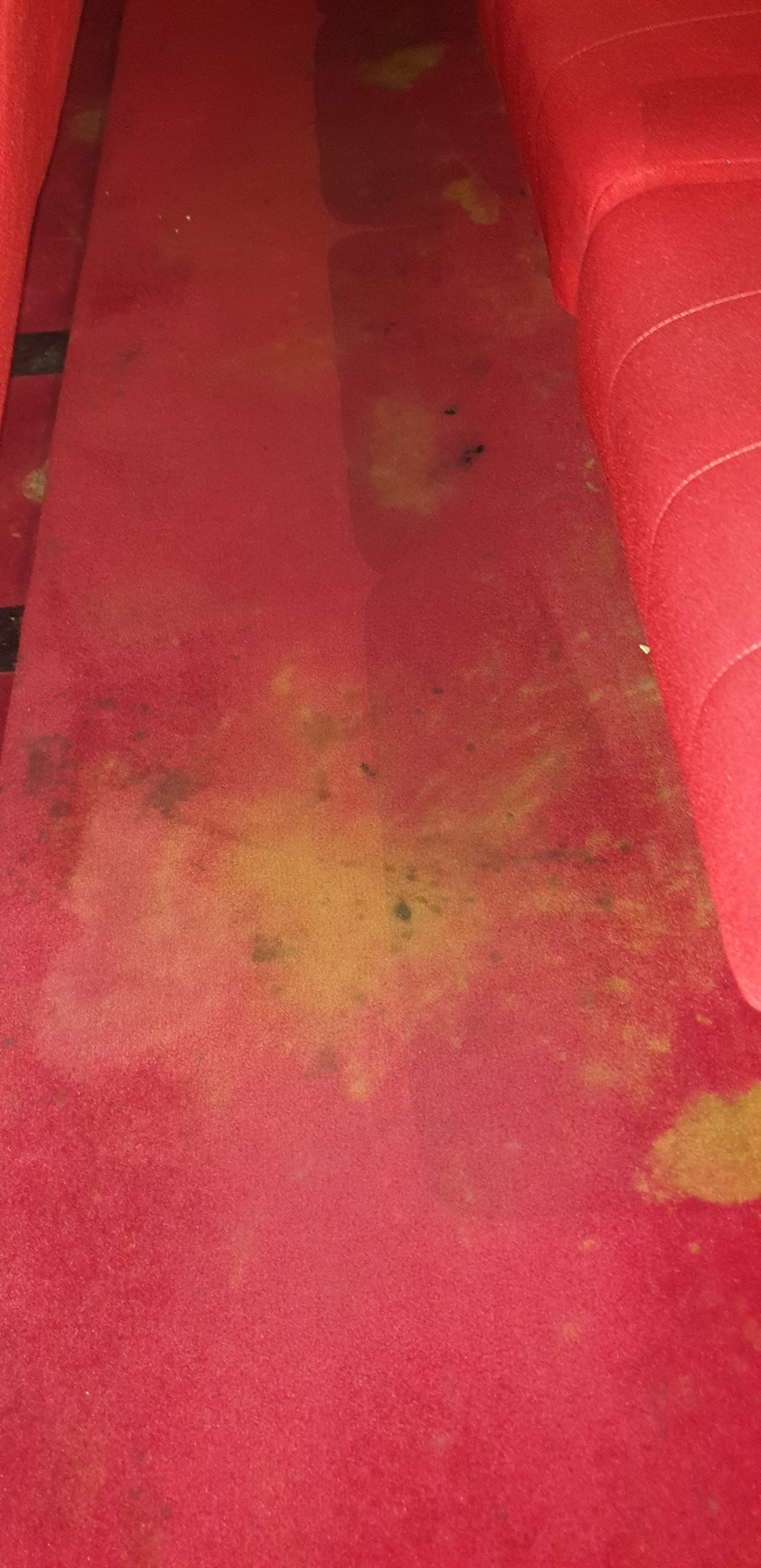 Before the clean: spill marks and grey soil worked into the red aisle carpet of a Perth cinema.