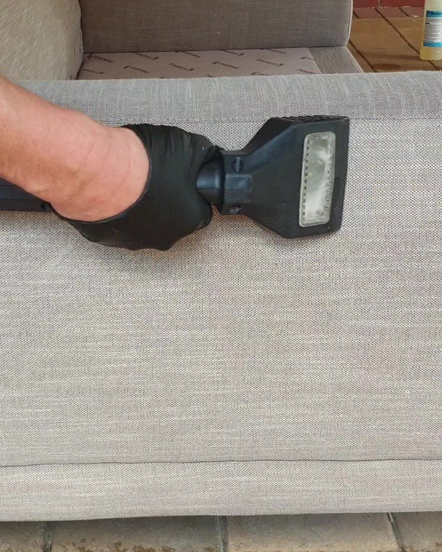 Our upholstery hand tool drawing the soil out of a grey fabric sofa arm, upholstery cleaning in Perth.