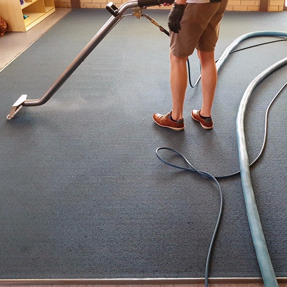 Commercial carpet steam cleaning in Perth, our hot water extraction wand rinsing the soil out of blue office carpet.