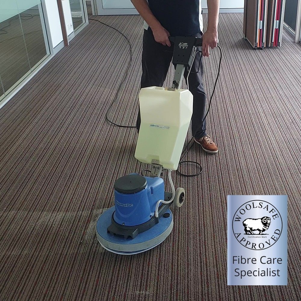 Wool carpet cleaning in a Perth office corridor by a WoolSafe Approved Fibre Care Specialist, the rotary machine on the pile.