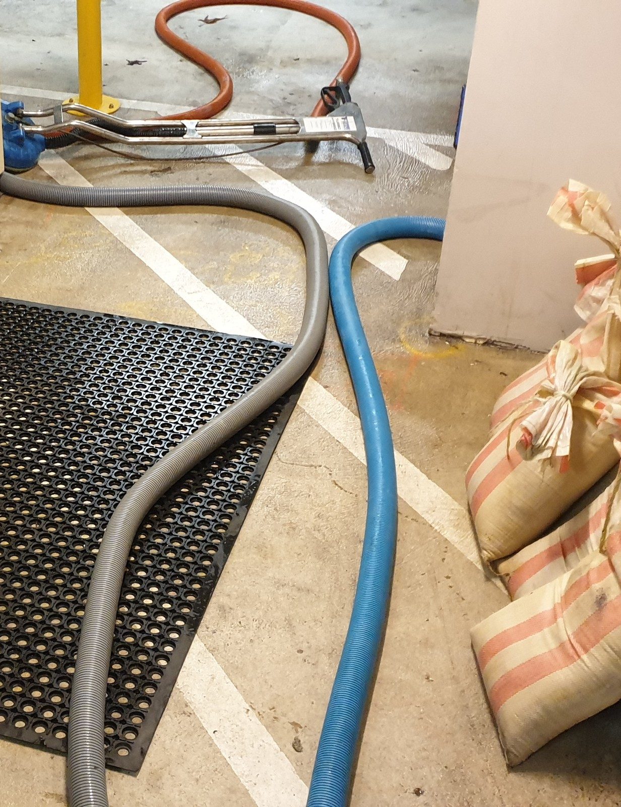 Our truck-mounted hoses run into a flooded basement lift lobby in Perth, clearing the water before it reaches the carpet beyond.