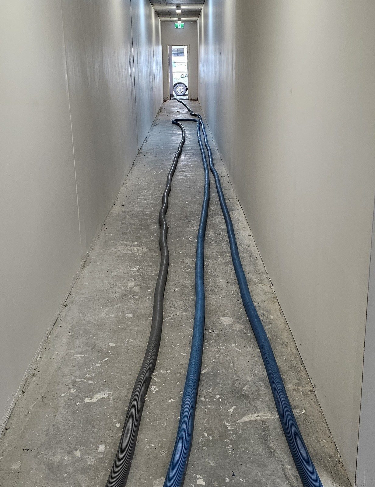 Our truck-mounted extraction hoses laid down a service corridor in Perth, on their way to a flooded basement car park.